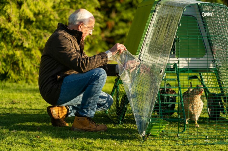 Man with his chickens in Omlet Eglu Go Up Chicken Coop with Omlet Weather Protection Cover