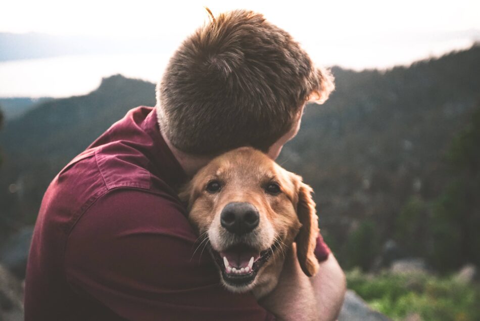 Man hugging Golden Retriever dog