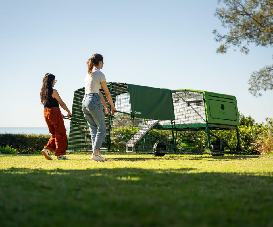 two-women-moving-the-eglu-pro-chicken-coop